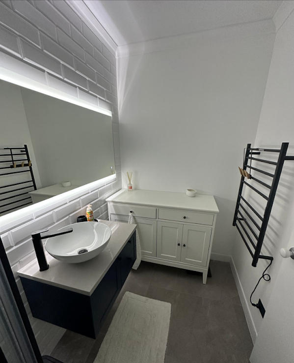 Minimalist bathroom vanity with LED mirror lighting and matte black fixtures