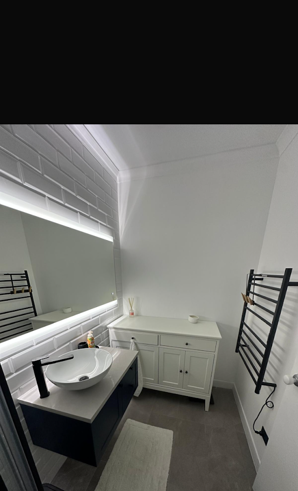 Minimalist bathroom vanity with LED mirror lighting and matte black fixtures