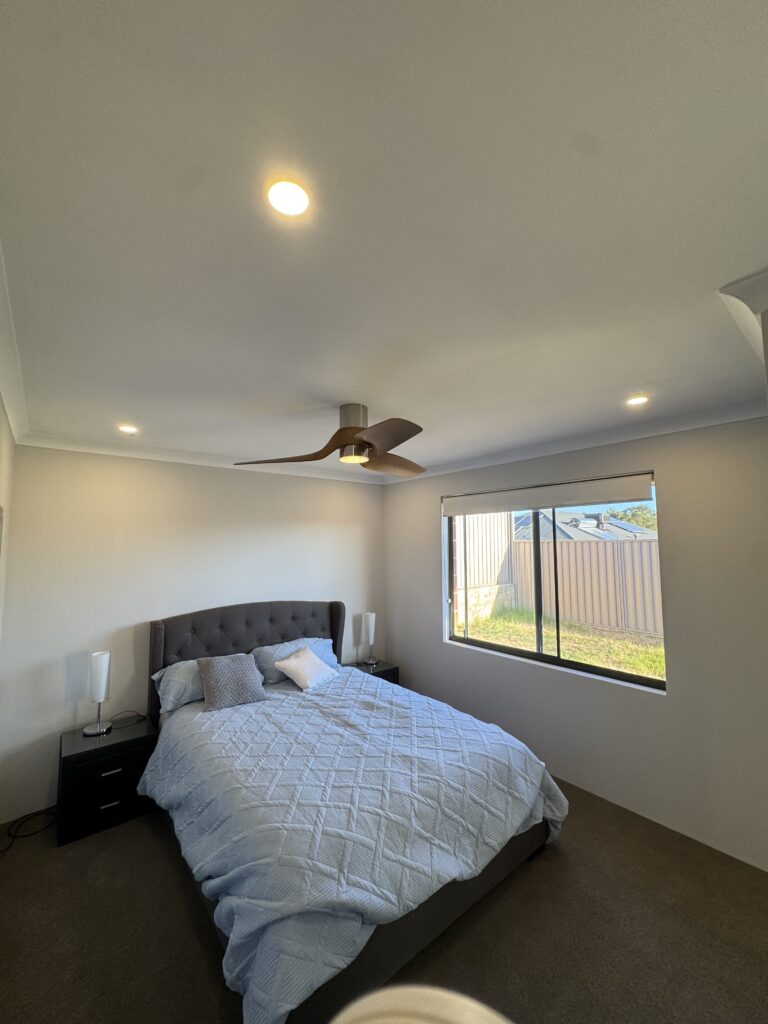 Modern bedroom with ceiling fan and recessed LED lighting