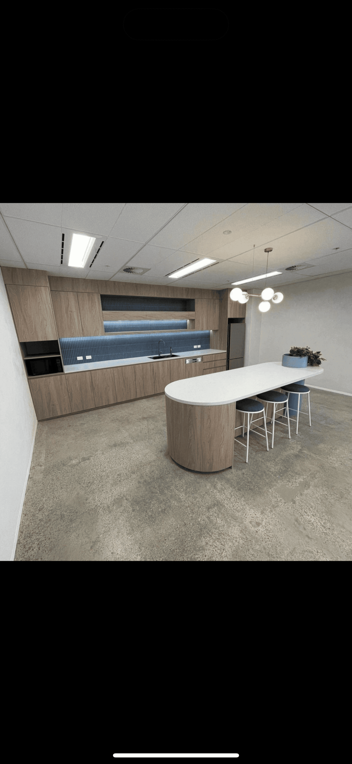 Stylish office kitchen with pendant and LED lighting installation