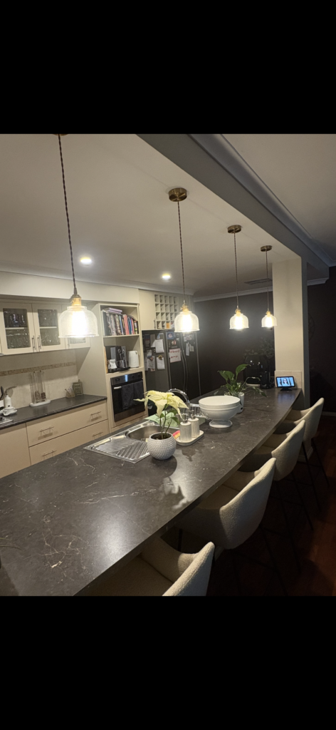Elegant kitchen pendant lighting installed above stone island bench