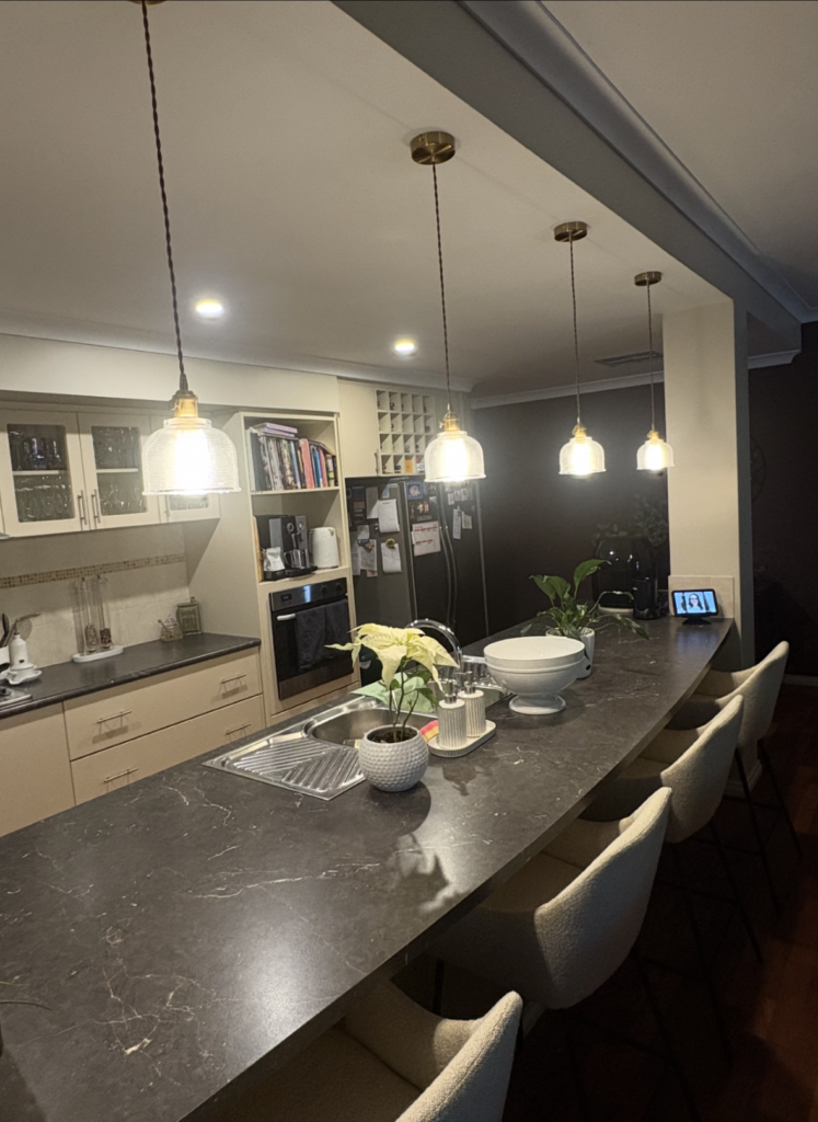 Elegant kitchen pendant lighting installed above stone island bench