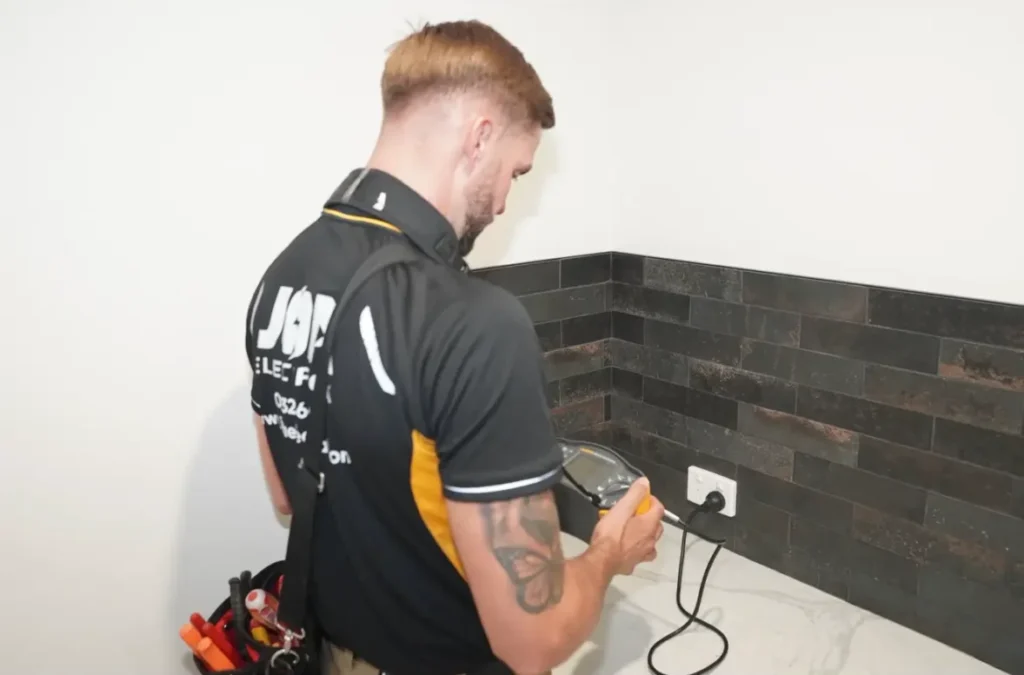 JOA Electrical electrician testing a power point with a multifunction tester during a safety inspection