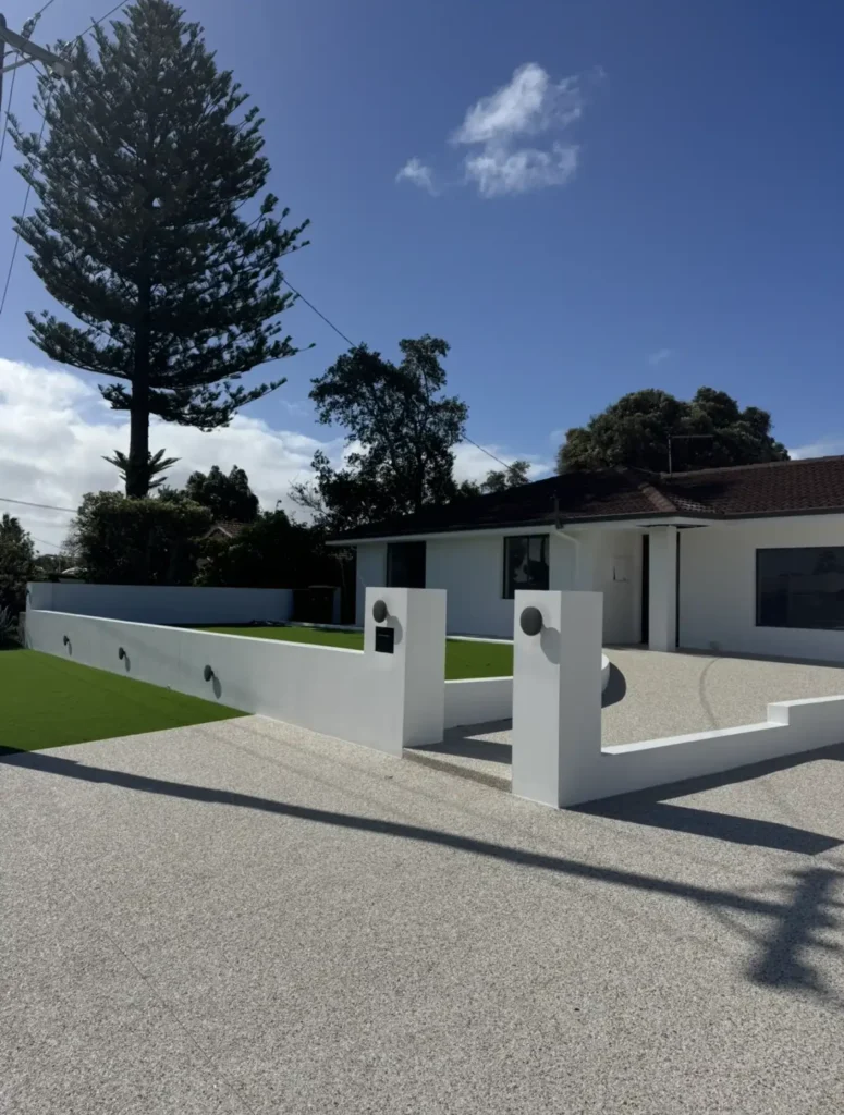 Front of a residential home with outdoor wall lights installed along the front fence