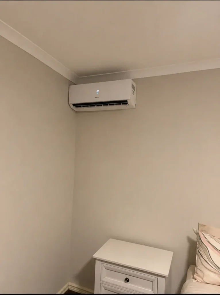 Wall-mounted split system air conditioner installed in a bedroom